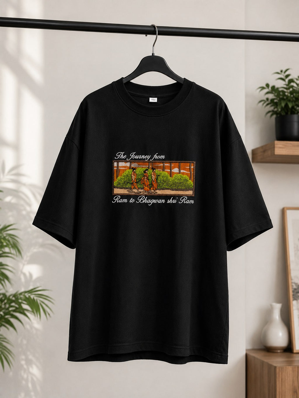 Black oversized tee with Ram, Sita and Lakshman forest embroidery on a hanger