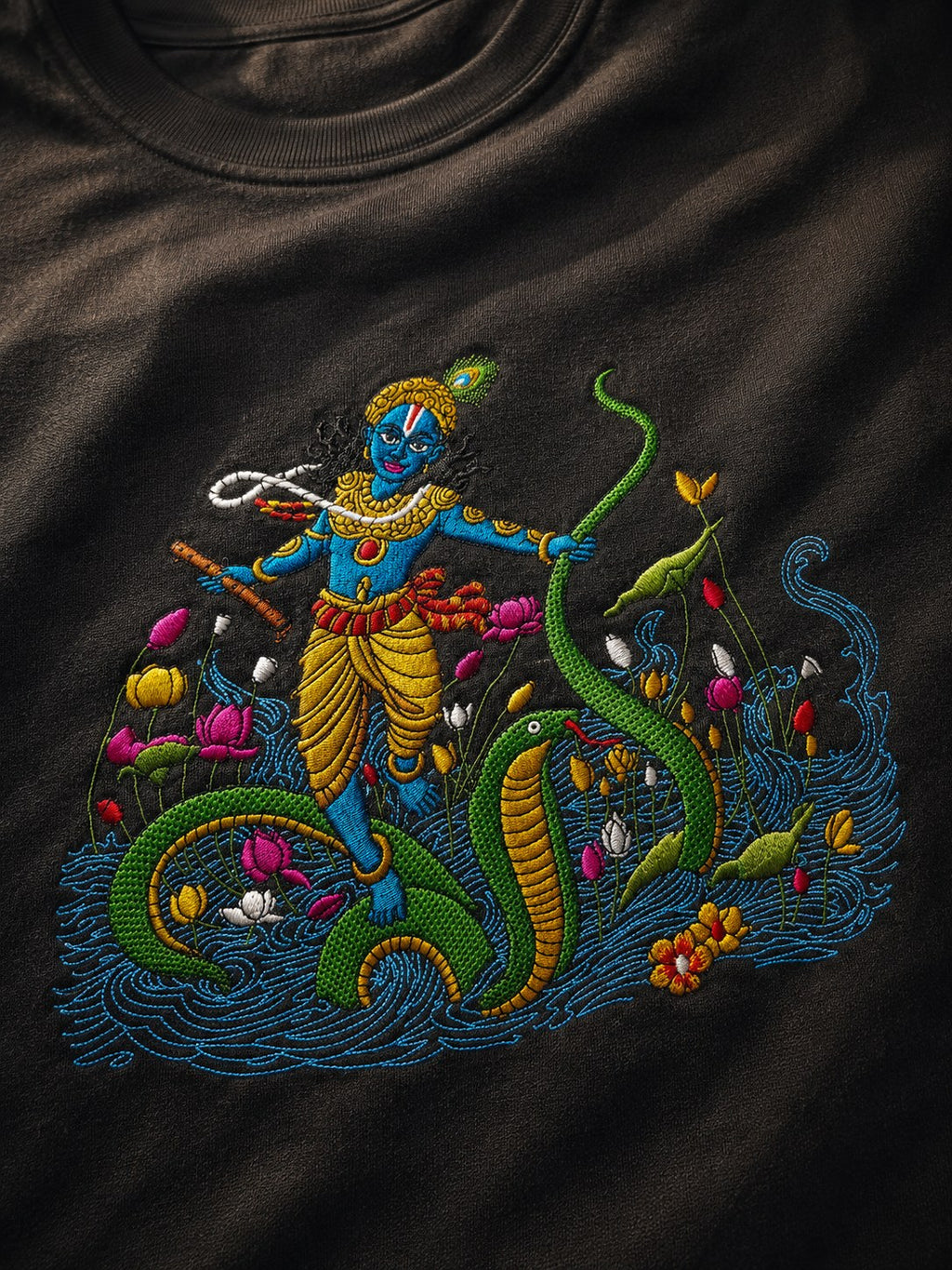 Close-up of Krishna dancing on Kaliya embroidery with lotuses and river