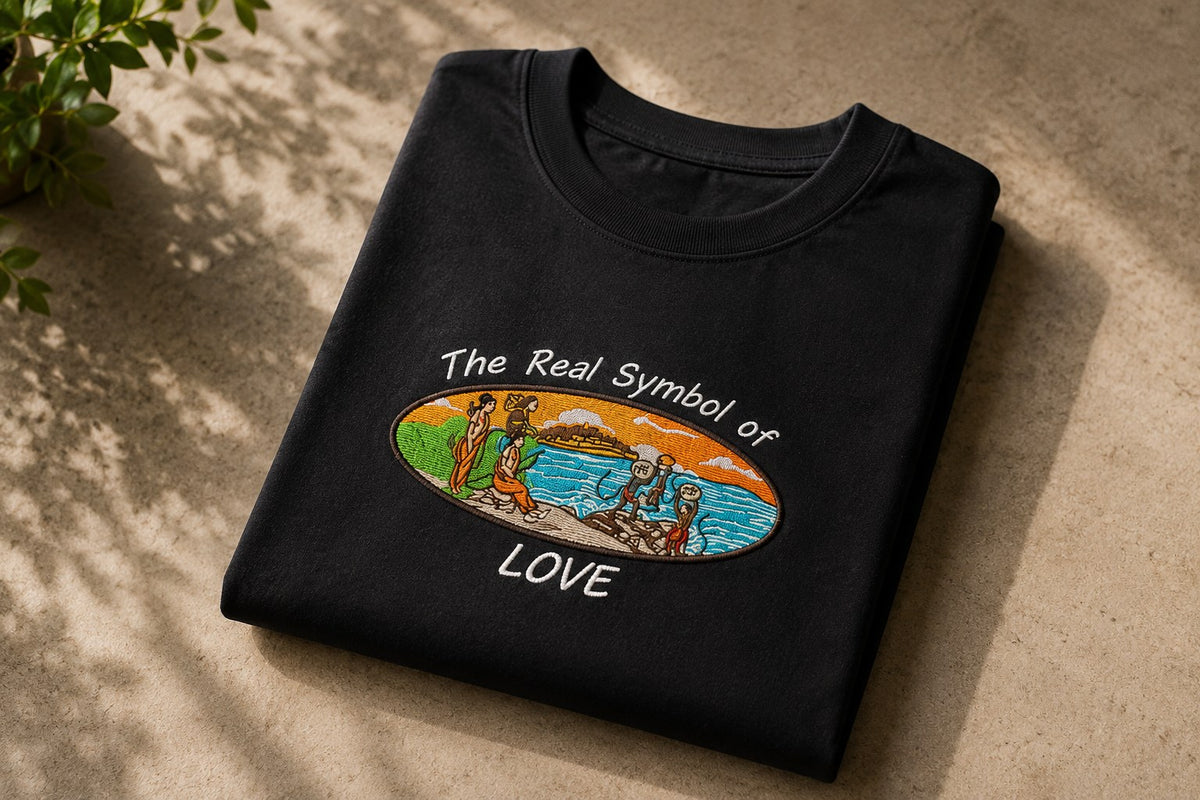 Folded Ram Setu embroidered tee on a warm wall in sunlight